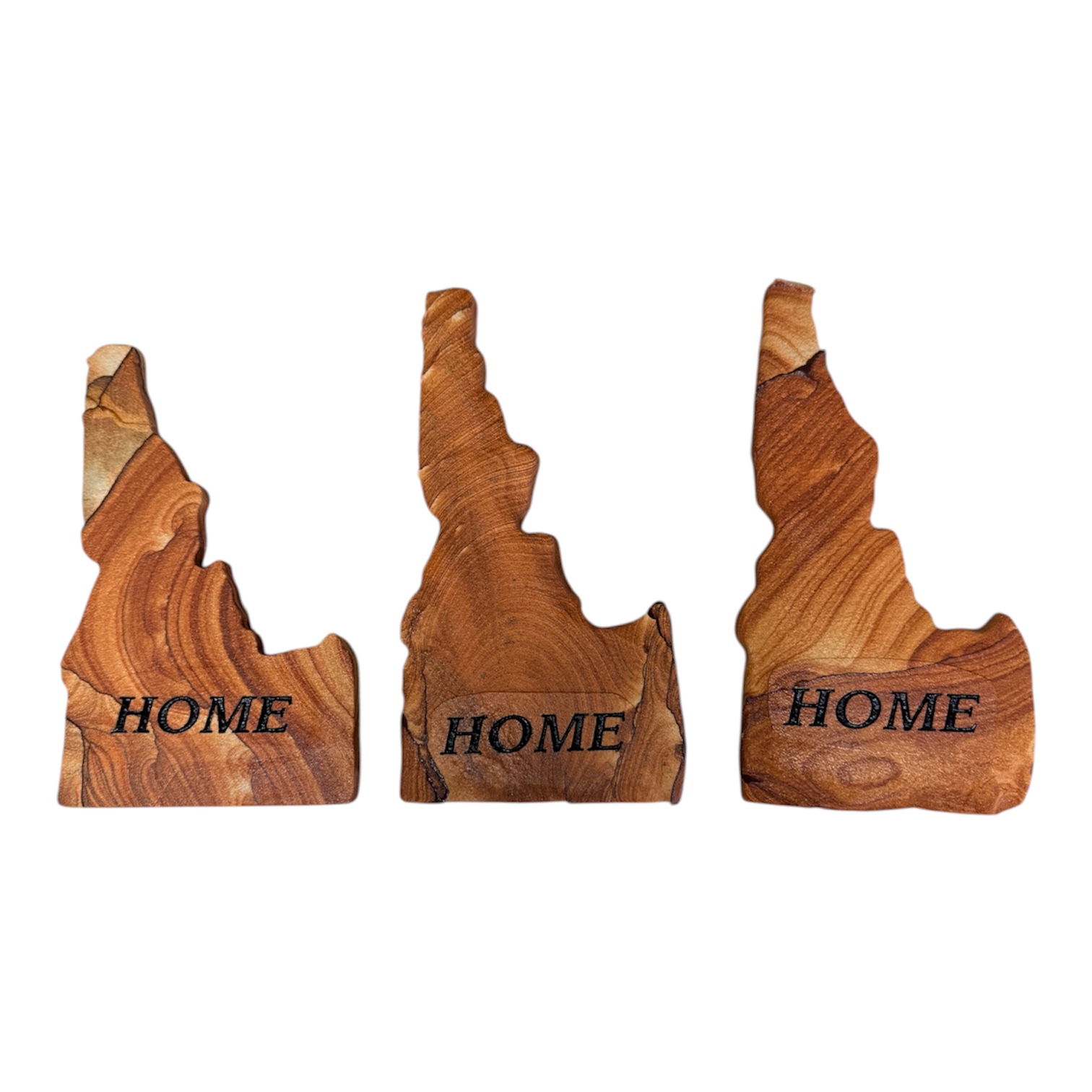 Three Idaho-shaped Arizona sandstone home decor pieces engraved with the word Home