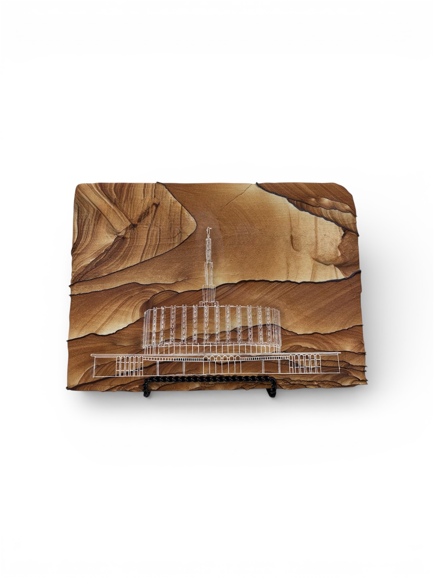 Detailed temple artwork engraved into natural Arizona sandstone with layered brown and tan stone patterns